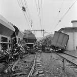 126222 Afbeelding van de ravage na een ontsporing van een goederentrein ter hoogte van de spoorwegovergang in het ...